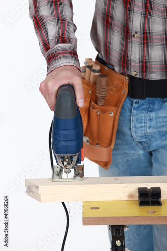 Photo: A cropped picture of a handyman using a jigsaw. A cropped picture of a handyman using a jigsaw.