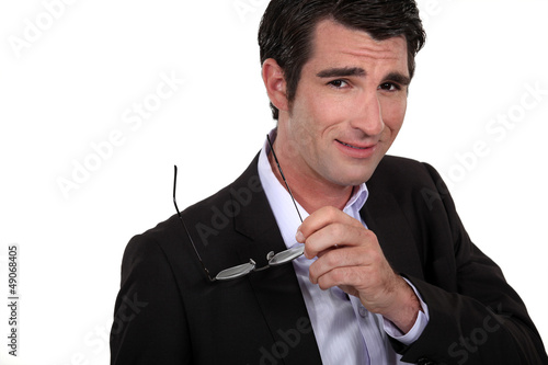 Photo: confident businessman holding his eyeglasses confident businessman holding his eyeglasses
