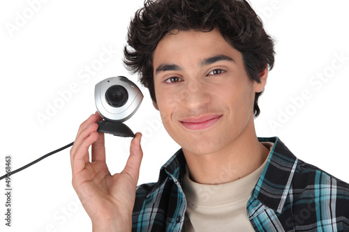 Photo: Young man holding a webcam Young man holding a webcam