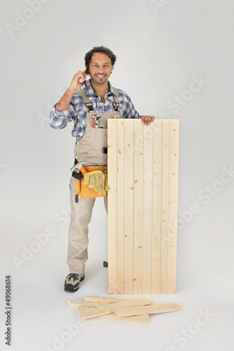 Photo: Carpenter stood with wooden door Carpenter stood with wooden door