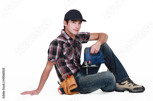 Photo: Tradesman holding a jigsaw Tradesman holding a jigsaw