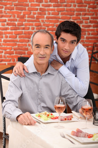 Photo: Father and son eating together in restaurant Father and son eating together in restaurant