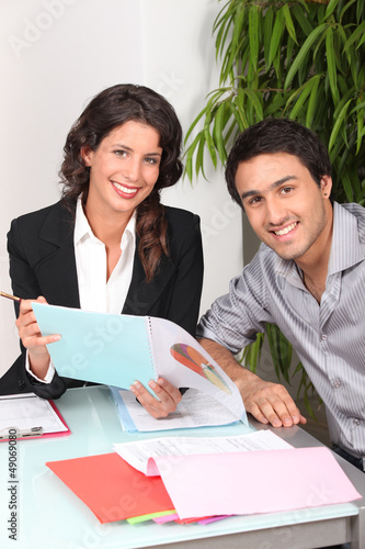 Photo: Two cheerful workers looking at financial information Two cheerful workers looking at financial information