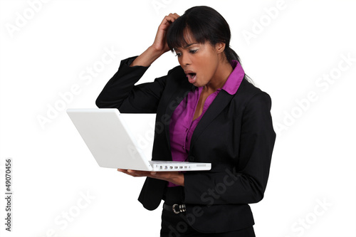 Photo: Businesswoman looking alarmed at her laptop Businesswoman looking alarmed at her laptop