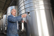 Winemaker with a glass of wine in the cellar