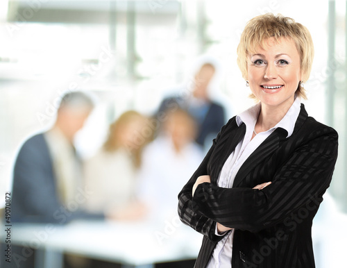 Photo: confident business woman with team behind confident business woman with team behind