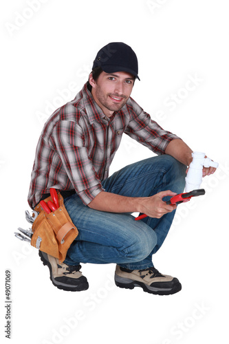 Photo: plumber holding a plastic pipe and a spanner plumber holding a plastic pipe and a spanner