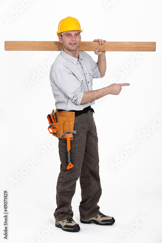 Photo: carpenter carrying plank over his shoulder carpenter carrying plank over his shoulder