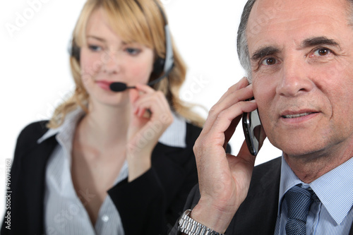 Photo: Boss and assistant making calls to customers Boss and assistant making calls to customers