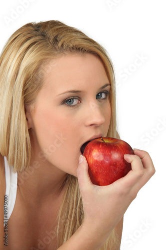 Photo: Blond woman eating red apple Blond woman eating red apple