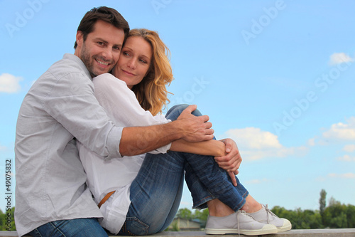 Photo: couple sitting on a wall couple sitting on a wall
