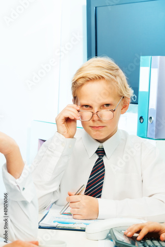 Photo: Thoughtful blond kid playing adult Thoughtful blond kid playing adult