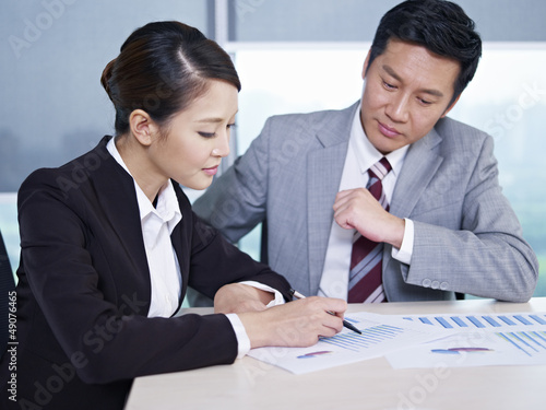 Photo: asian business people discussing sales performance asian business people discussing sales performance