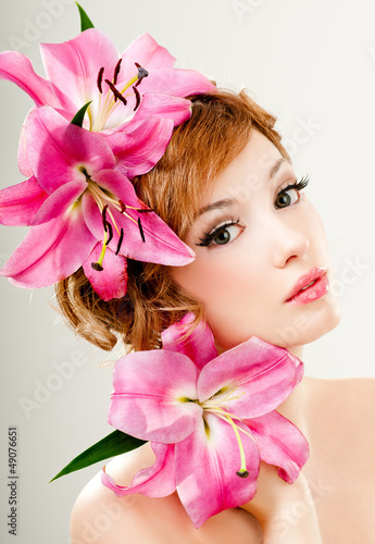 Photo: beautiful girl with pink lilies in her hair beautiful girl with pink lilies in her hair