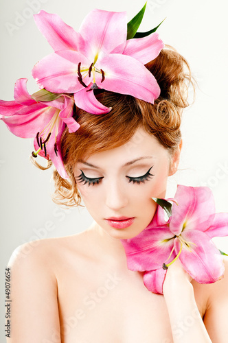 Photo: beautiful girl with pink lilies in her hair beautiful girl with pink lilies in her hair