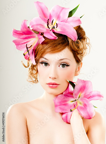 Photo: beautiful girl with pink lilies in her hair beautiful girl with pink lilies in her hair