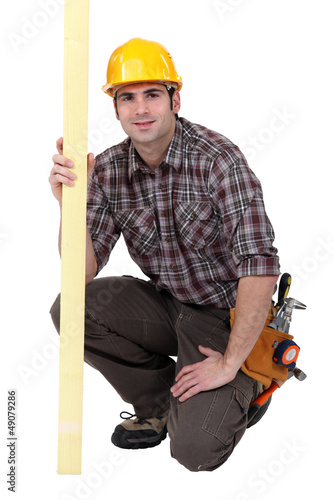 Photo: A kneeled male carpenter. A kneeled male carpenter.