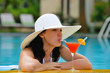 Photo: girl with a cocktail at the edge of the swimming pool girl with a cocktail at the edge of the swimming pool