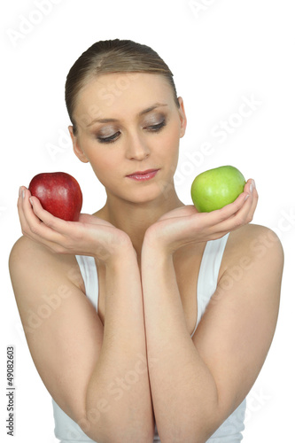 Photo: Woman holding a green and red apple Woman holding a green and red apple