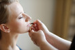 Young beautiful bride applying wedding make-up