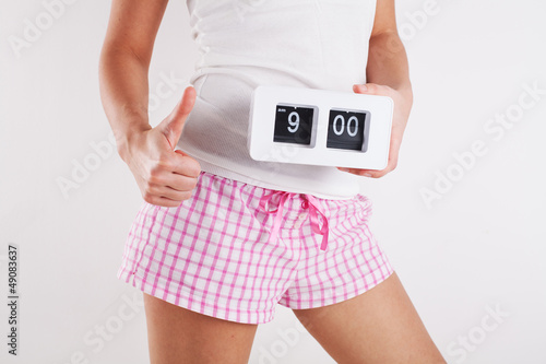 Photo: Young woman holding clock Young woman holding clock