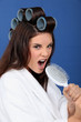 Woman with hair curlers singing in a brush