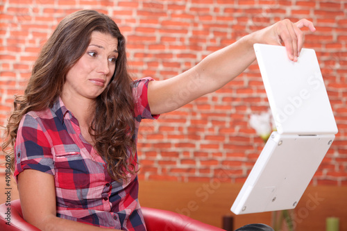 Photo: Woman disgusted by her laptop Woman disgusted by her laptop