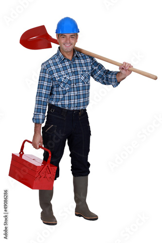 Photo: Mason carrying spade and tool kit Mason carrying spade and tool kit