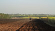 Small scale farming with tractor and plow in field