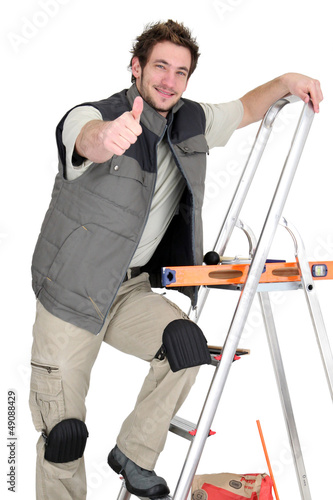 Photo: Tiler climbing ladder whilst giving the thumbs-up Tiler climbing ladder whilst giving the thumbs-up