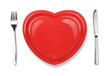 Knife, red plate in heart shape and fork isolated on white