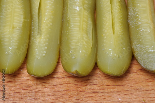 Photo: Quarters pickled cucumbers on a wooden worktop Quarters pickled cucumbers on a wooden worktop