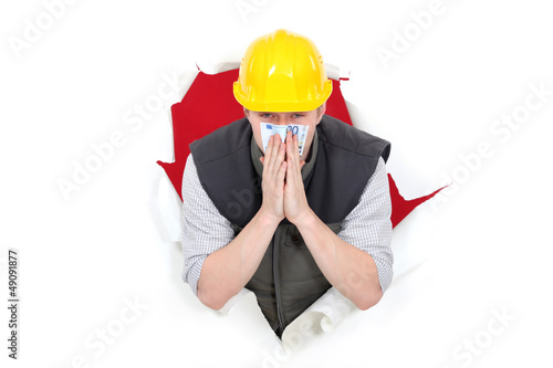 Photo: Builder smelling bank note Builder smelling bank note