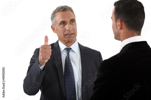 Photo: mature businessman thumb up with businesspartner mature businessman thumb up with businesspartner