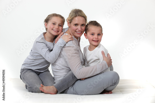 Photo: mother embracing her two little girls mother embracing her two little girls