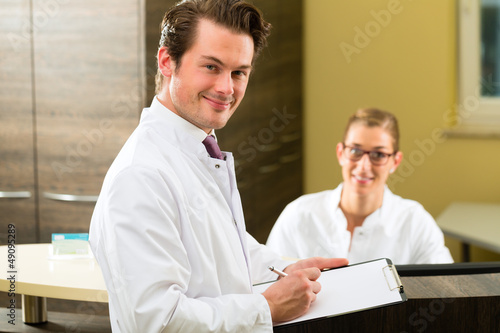 Photo: Dentist with clipboard in his surgery Dentist with clipboard in his surgery