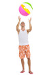 Photo: Full length portrait of young man playing with beach ball Full length portrait of young man playing with beach ball