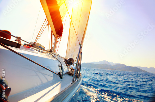Photo: Yacht Sailing against sunset. Sailboat. Yachting. Sailing Yacht Sailing against sunset. Sailboat. Yachting. Sailing