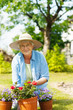 Senior woman with flowers in garden