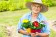 Senior woman with flowers in garden