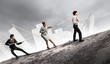 Three business people pulling rope