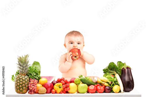 Photo: Cute baby boy sitting on a table with fruits and vegetables and Cute baby boy sitting on a table with fruits and vegetables and