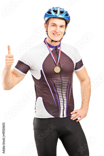 Photo: Winner male cyclist with a golden medal giving a thumb up Winner male cyclist with a golden medal giving a thumb up