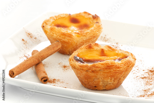 Photo: Custard Pies over a white plate with cinnamon sticks Custard Pies over a white plate with cinnamon sticks