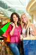 Two women shopping with bags in mall