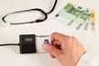 Arzt steckt Gesundheitskarte in Kartenleser