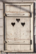 Heart shape look out on wooden door to outhouse.