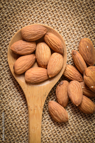 Photo: Almonds in a Wodden Spoon on a Burlap Background Almonds in a Wodden Spoon on a Burlap Background