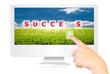 Hand pushing Success word on monitor screen.