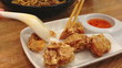 Eating fried chicken dip in sweet and spicy sauce